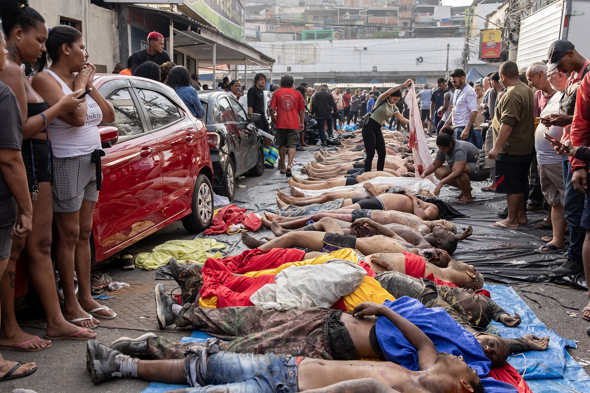 Families search for relatives among bodies in São Lucas Square, Rio de Janeiro, Brazil following a police raid that left at least 122 dead. This operation in the Penha complex is the deadliest in Brazilian history, surpassing the casualties of the 1992 Carandiru massacre.